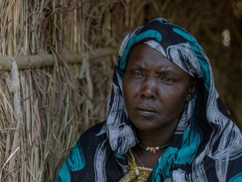 Die 40-jährige sudanesische Flüchtling Hawa steht in ihrer Unterkunft im Transitzentrum Kurmuk in der Region Benishangul-Gumuz im Nordwesten Äthiopiens. Die zehnfache Mutter floh im Juni 2023 mit ihren Kindern und ihrer 80-jährigen Mutter vor der Gewalt im Sudan. © UNHCR/Tiksa Negeri