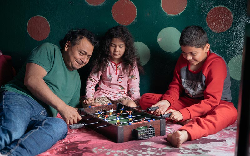 Honduran refugee plays a football game with his children at their home in northern Mexico. 