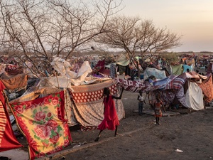 أطفال يلعبون قرب مخيمٍ عشوائي مرتجل.