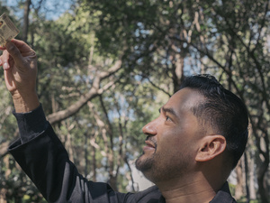 Un homme regarde une carte d'identité qu'il brandit.