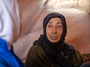 سناء خالد، 55 عاماً، تتحدث مع موظفة من المفوضية داخل خيمة عائلتها في مخيم غير رسمي في ريف إدلب، شمال غرب سوريا.