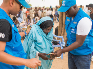 اللاجئة السودانية خديجة محمد علي، 72 عاماً، تتلقى المساعدة من موظفي المفوضية في موقع مادجيجيلتا في منطقة أوداي في تشاد، على الحدود مع السودان.