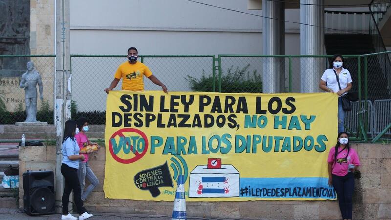 Protesters holding a banner saying "no law for displaced persons, no vote for deputies" (translated from Spanish)