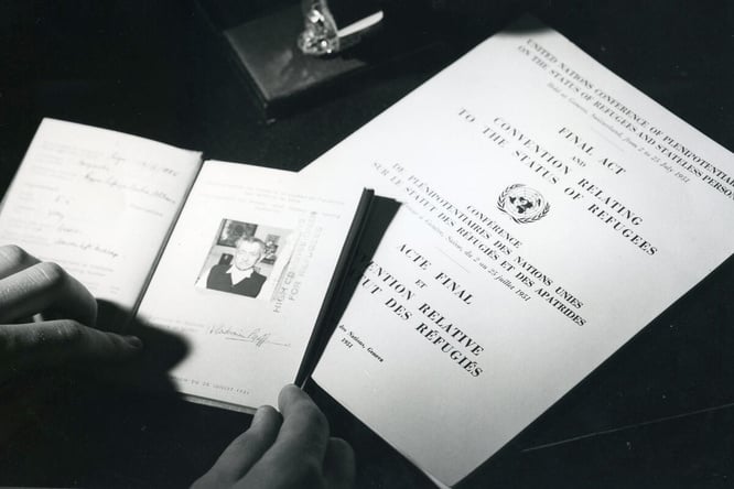 A black and white photo showing travel documents and The Convention Relating to the Status of Refugees.