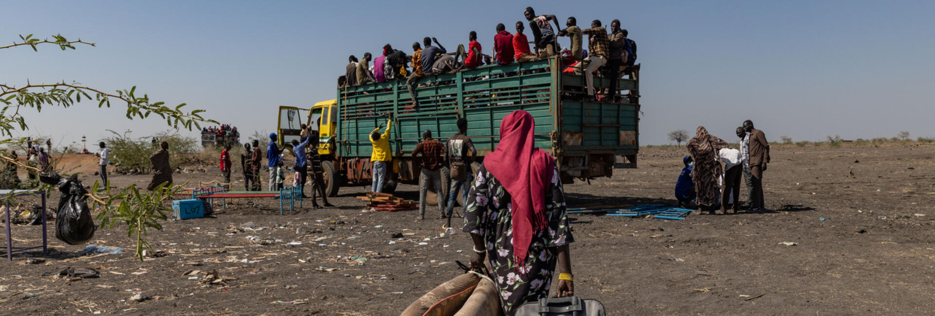 عائدون جنوب سودانيون ولاجئون سودانيون ممن اضطروا للفرار من الصراع، يستقلون شاحناتٍ عند معبر جودة الحدودي قرب بلدة الرنك في جنوب السودان.
