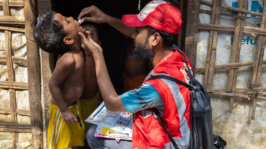 Bangladesh. A community health volunteer administers cholera medicine to a young child in the Rohingya refugee camps