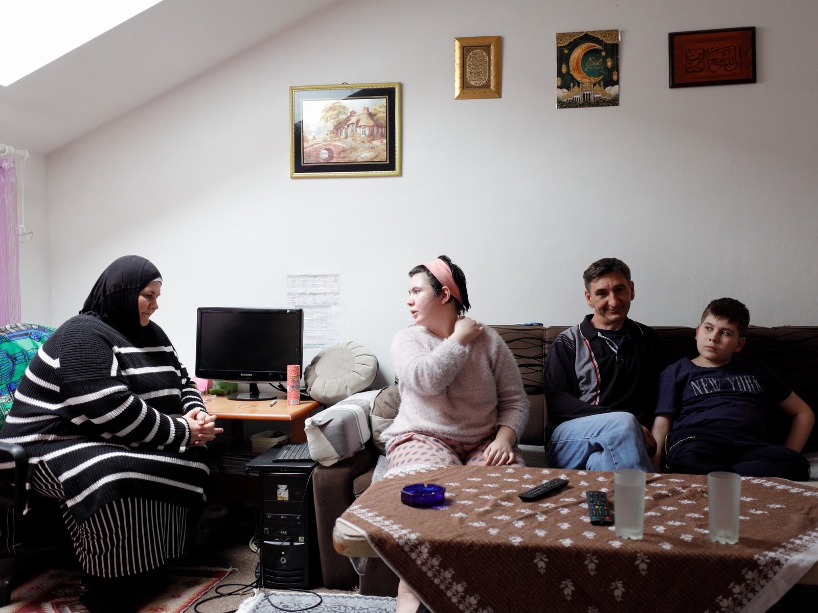 Anes, 50, second from the right, spends time with his family in his apartment, provided by the Regional Housing Programme in Bosnia and Herzegovina.
