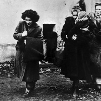 Black and white photo of three women and a child arriving at a refugee camp in Austria.
