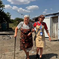 Older Ukrainian woman walking with the social facilitator