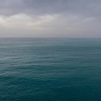 A view of the sea with dark clouds on the horizon