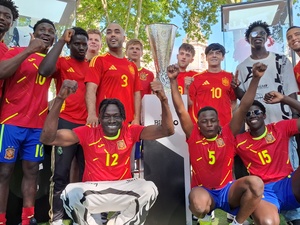 Spanish Refugee National Football Team in red football uniforms pose for picture.