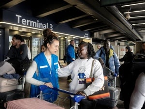 A UNHCR staff member welcoming a refugee student