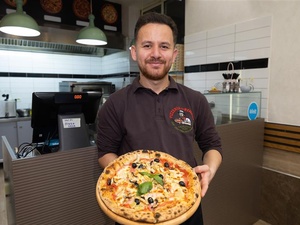 A man holding a pizza