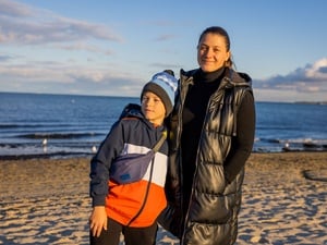 A mother and her son standing in front of the sea