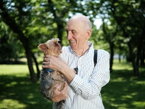 A man holding a small dog