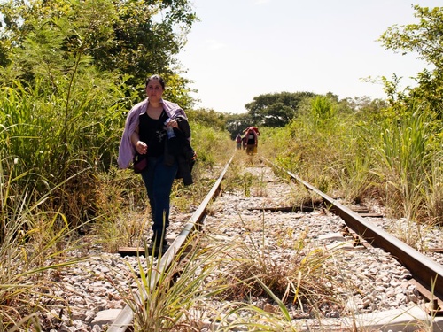 A woman fleeing El Salvador walks along the train tracks in Chiapas, Mexico.