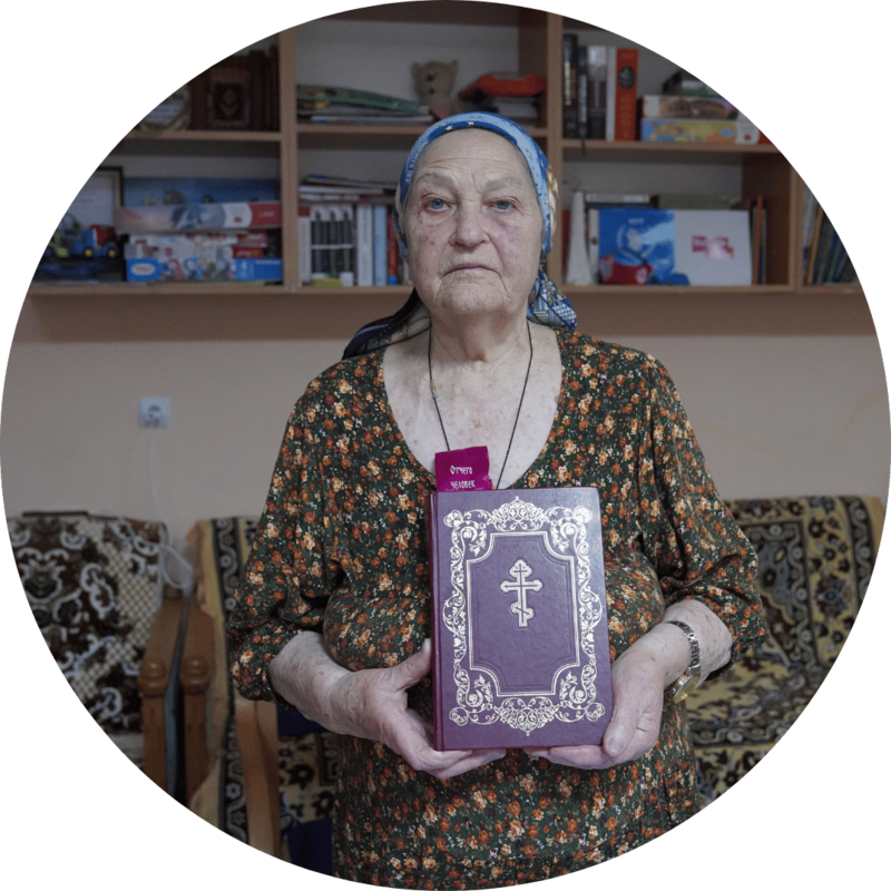 An older Ukrainian woman poses with her bible