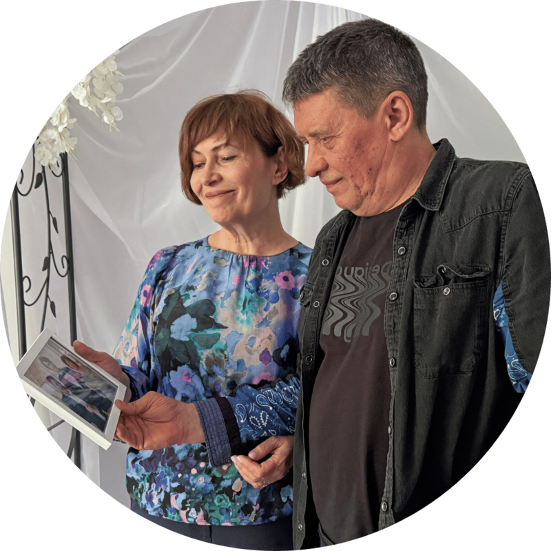 A Ukrainian couple looking at a framed family portrait