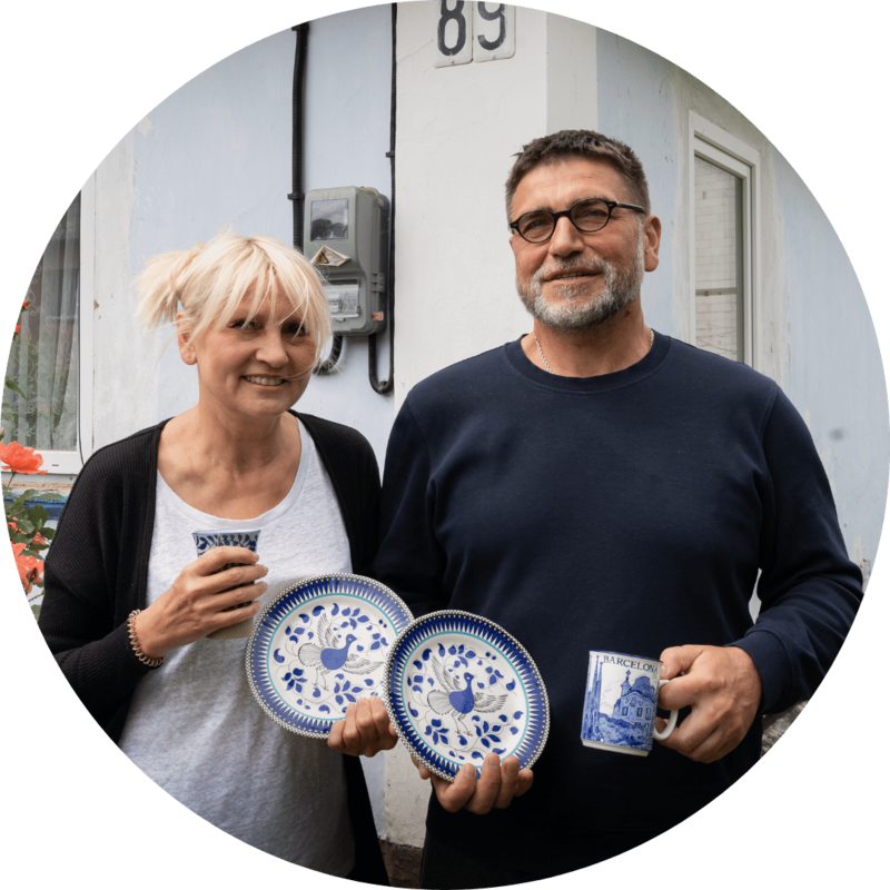A couple in Ukraine posing with ceramic plates and cups