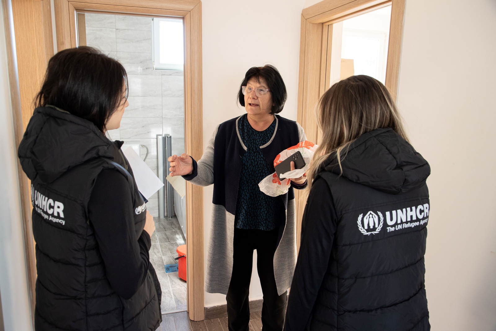 Senka, middle, shows UNHCR staff around her house which was provided by the Regional Housing Programme in 2023. 