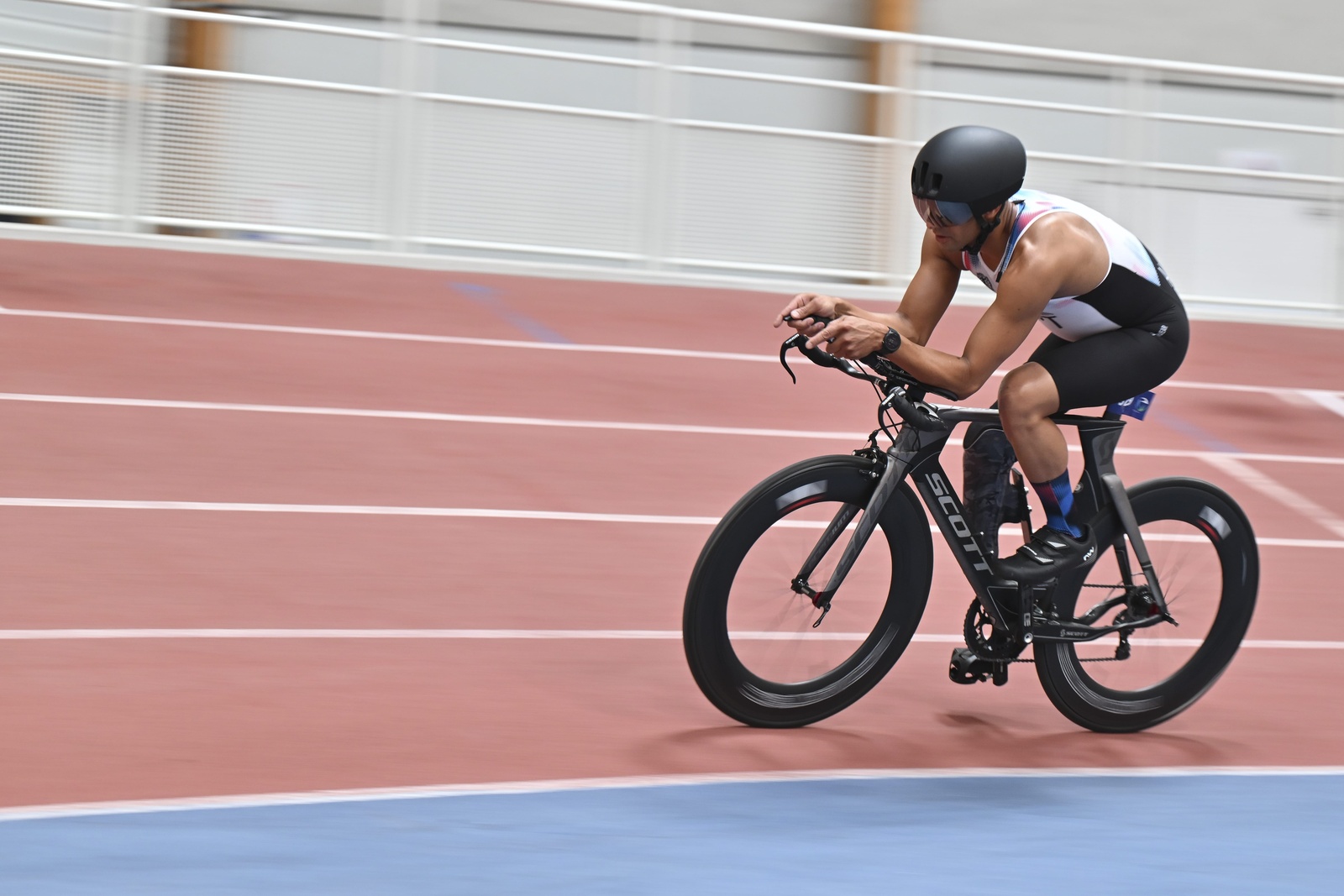 A man on a bicycle races round a track