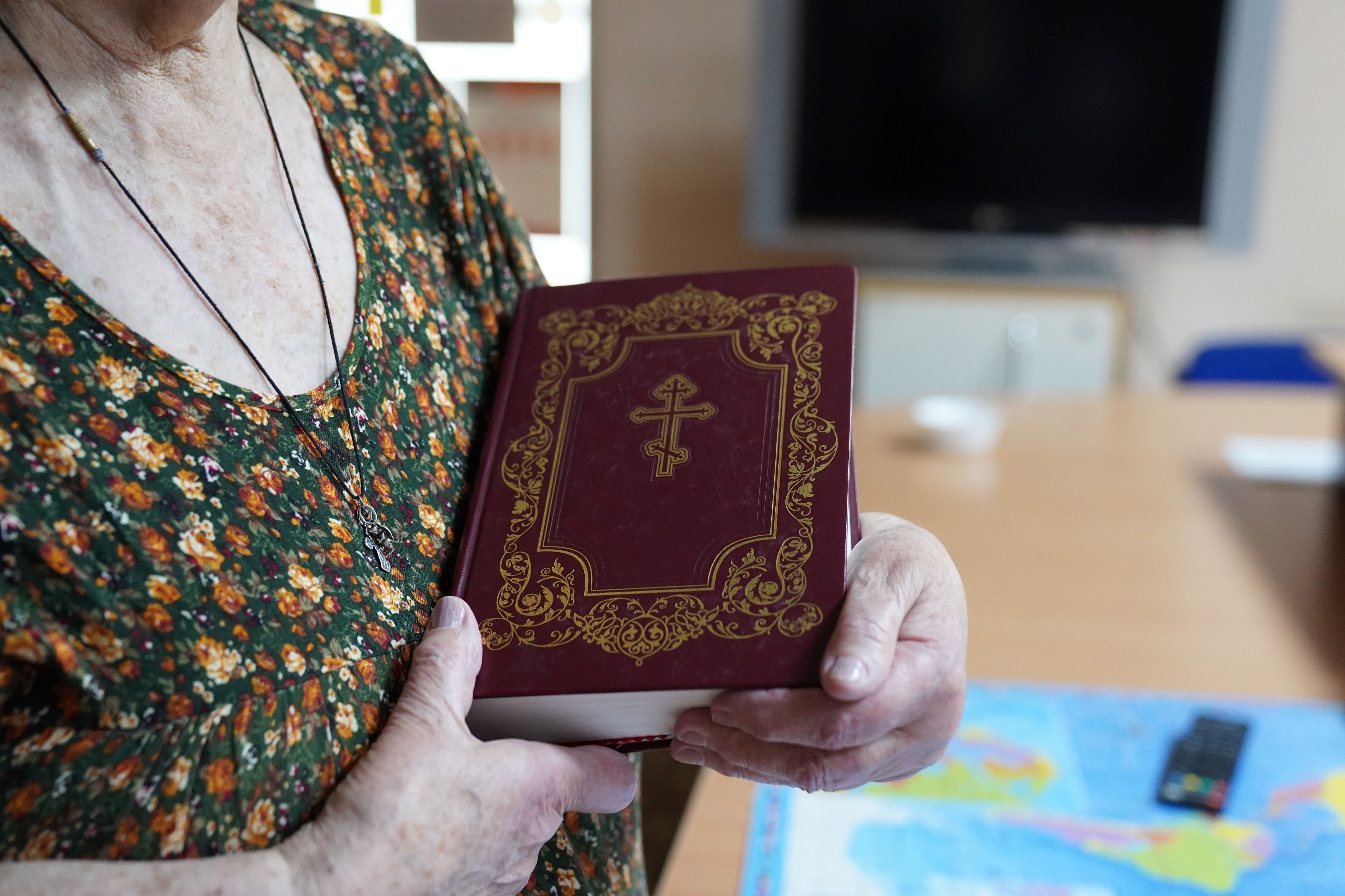 An older woman holding a bible in both hands