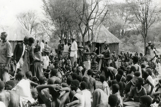 Black and white photo of a group of Angolan refugees waiting for food rations