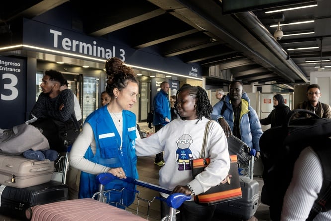 A UNHCR staff member welcoming a refugee student