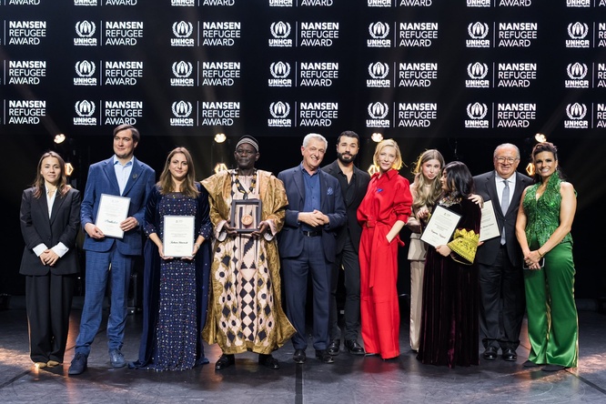 A group of people stand in a line on a stage
