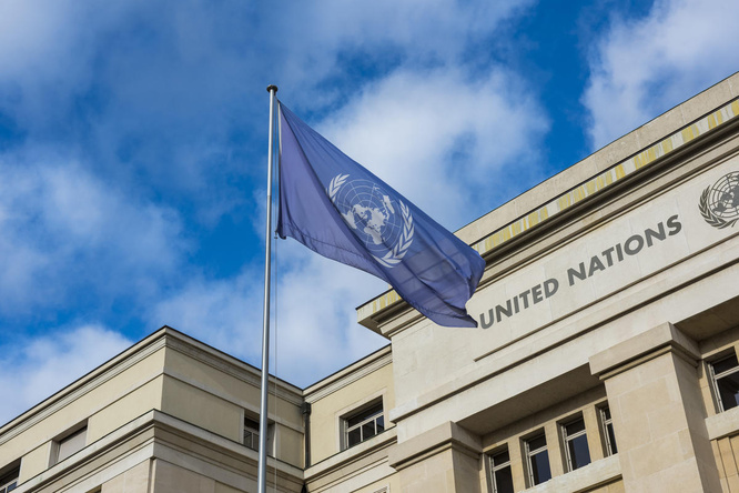 A UN flag flies in front of the Palais des Nations in Geneva. 