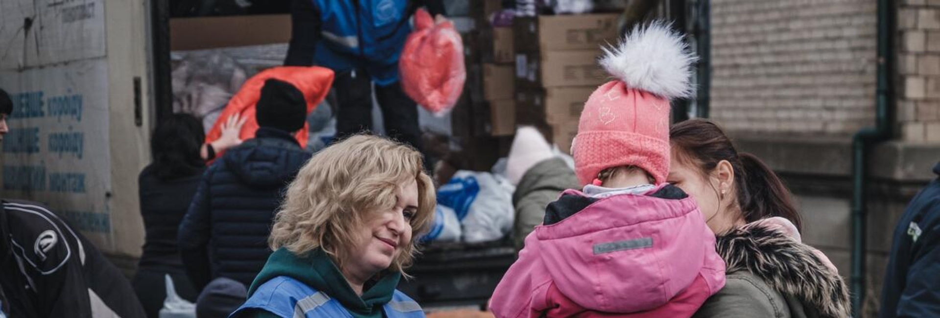 Anzhela (24) holds her little niece Liliya (4) as they wait to receive warm clothes and blankets.