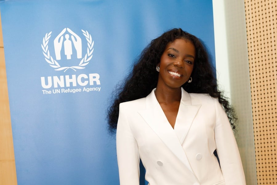 A photo of Jenny BSG next to a UNHCR banner