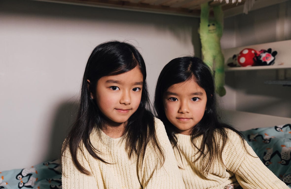 Two young girls in matching knitted sweaters.