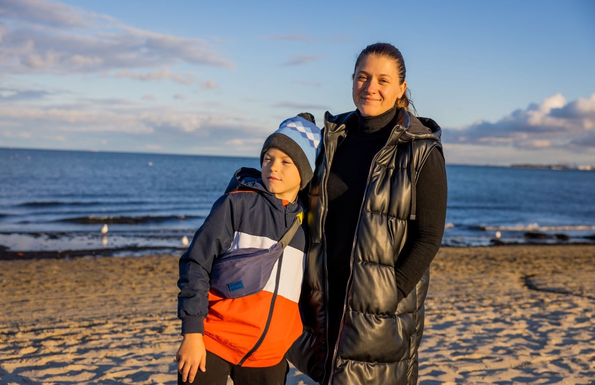 A mother and her son standing in front of the sea