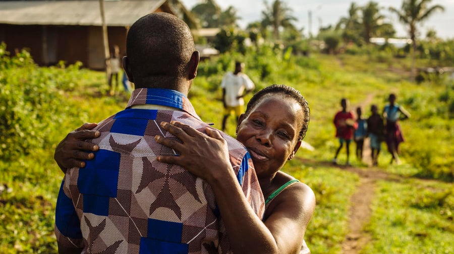 A former refugee from Côte d'Ivoire hugs his aunt.
