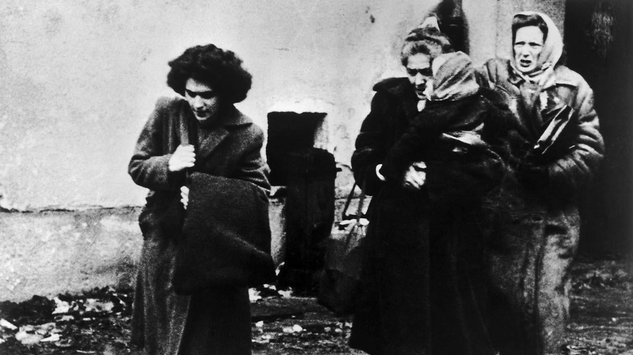 Black and white photo of three women and a child arriving at a refugee camp in Austria.