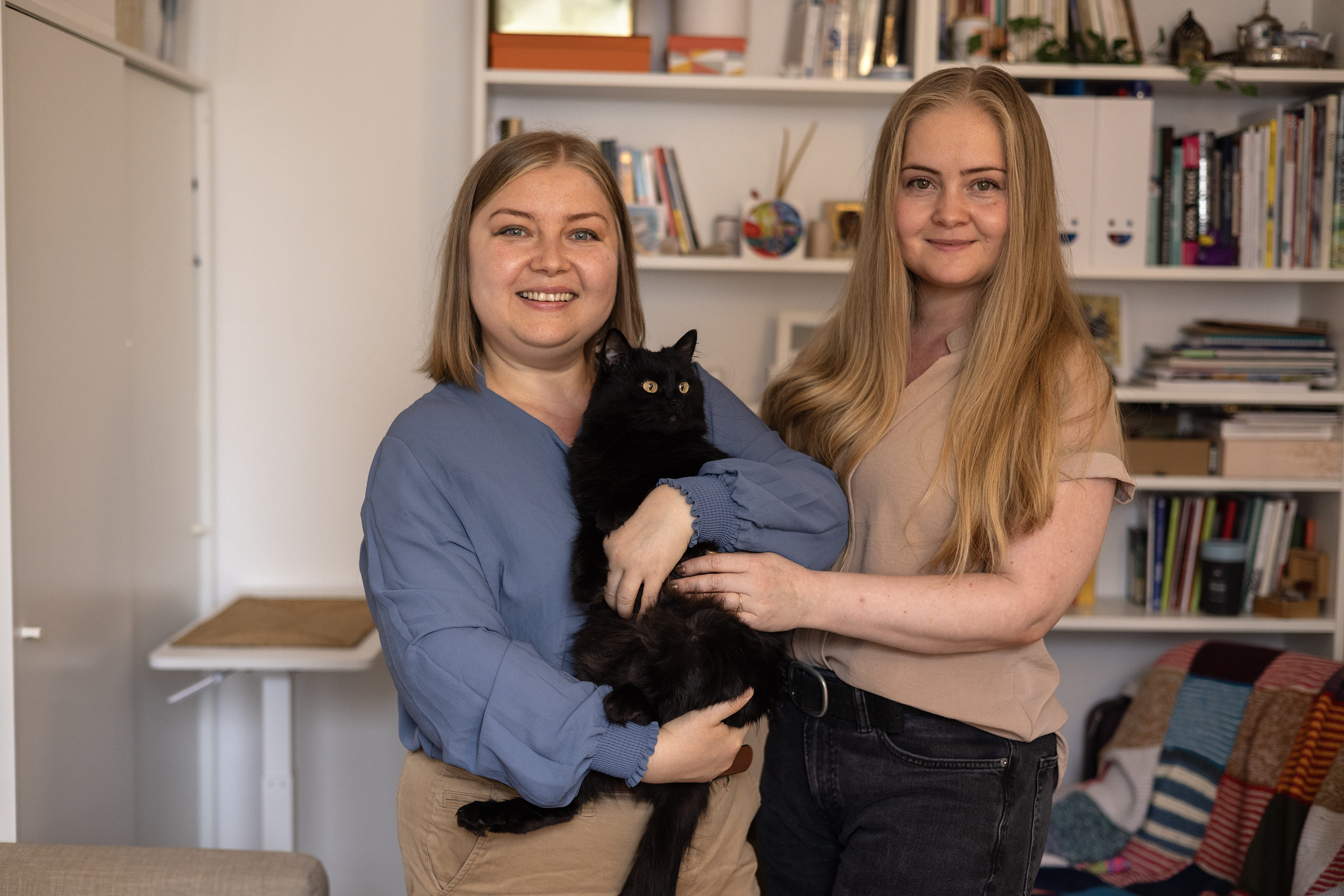 Anastasiia (à gauche) avec sa sœur Tania et leur chat Kotya, dans leur maison à Paris, France.