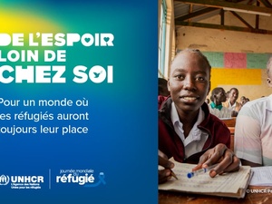 Deux filles assises à un bureau dans une salle de classe. Sur la gauche, un texte indique "L'espoir loin de chez soi".