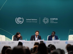L'acteur et ambassadeur de bonne volonté du HCR Theo James (au centre) et Opira Bosco Okot (à droite), réfugié et militant pour le climat, lors du lancement du réseau des « Réfugiés pour l'action climatique » à la COP29.