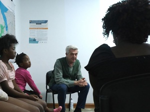 Filippo Grandi sits in a room, in discussion with three persons in transit