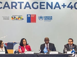 Quatre personnes sont assises à une table avec des microphones lors d'une réunion du processus, avec "Cartagena+40" et divers logos sur le mur derrière eux.