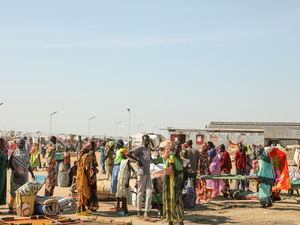 Un groupe de personnes est rassemblé avec leurs affaires personnelles.