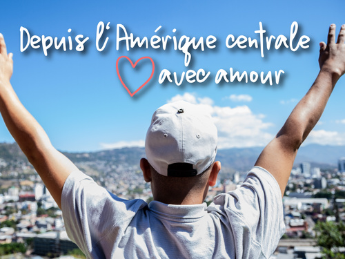 Une personne se tient debout, les bras en l'air, et regarde une ville.