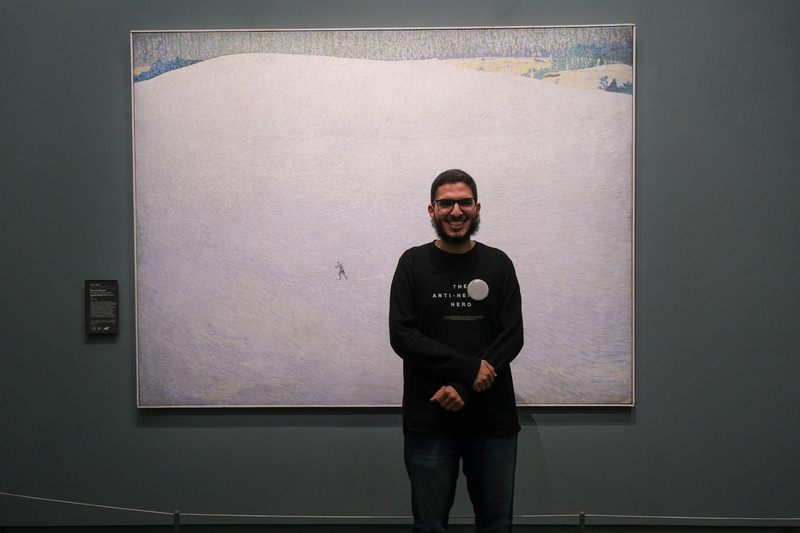 Murad Al-Osimi pose devant le tableau Schneelandschaft de Cuno Amiet.