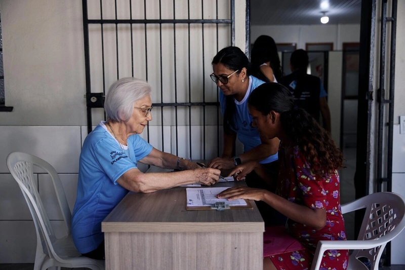 Au bureau de l'IMDH à Boa Vista, Sœur Rosita enregistre une jeune mère vénézuélienne pour une distribution de colis alimentaires.
