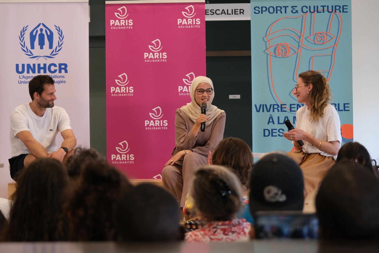 Alexis Michalik (à gauche), dramaturge, metteur en scène et acteur et Masomah Ali Zada (au centre), cheffe de mission de l'équipe olympique des réfugiés à Paris 2024 participent à une carte blanche animée par le média Komune à la Maison des réfugiés. 
