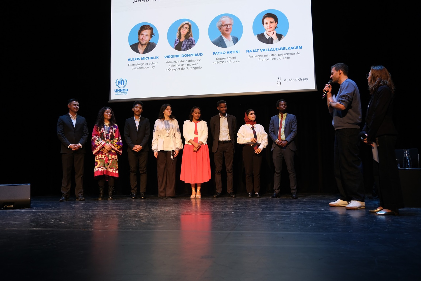 Les participants de la troisième édition du concours d'éloquence "Voix en Exil" du HCR sont sur scène avec le président du jury, Alexis Michalik, dramaturge et acteur.