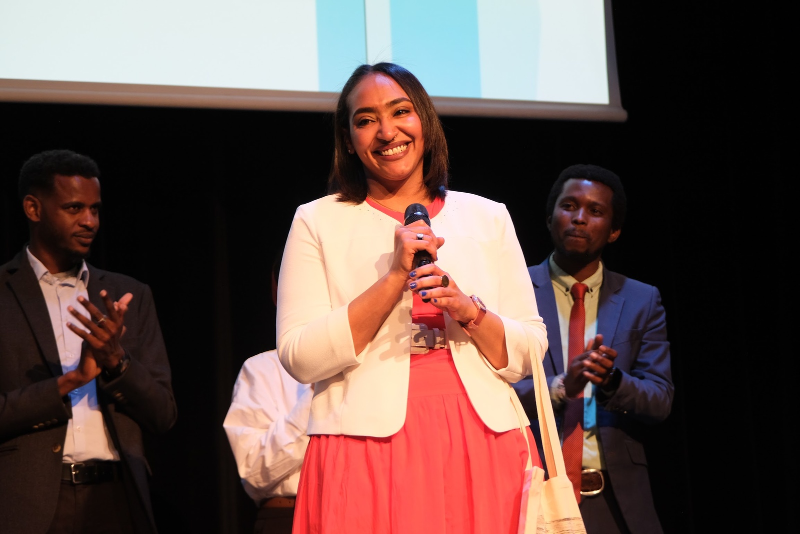 Shema, étudiante à l'Ecole de travail social Croix Saint Simon, réfugiée du Soudan, sous les applaudissements du public lors de la troisième édition du concours d’éloquence "Voix en Exil" du HCR. 