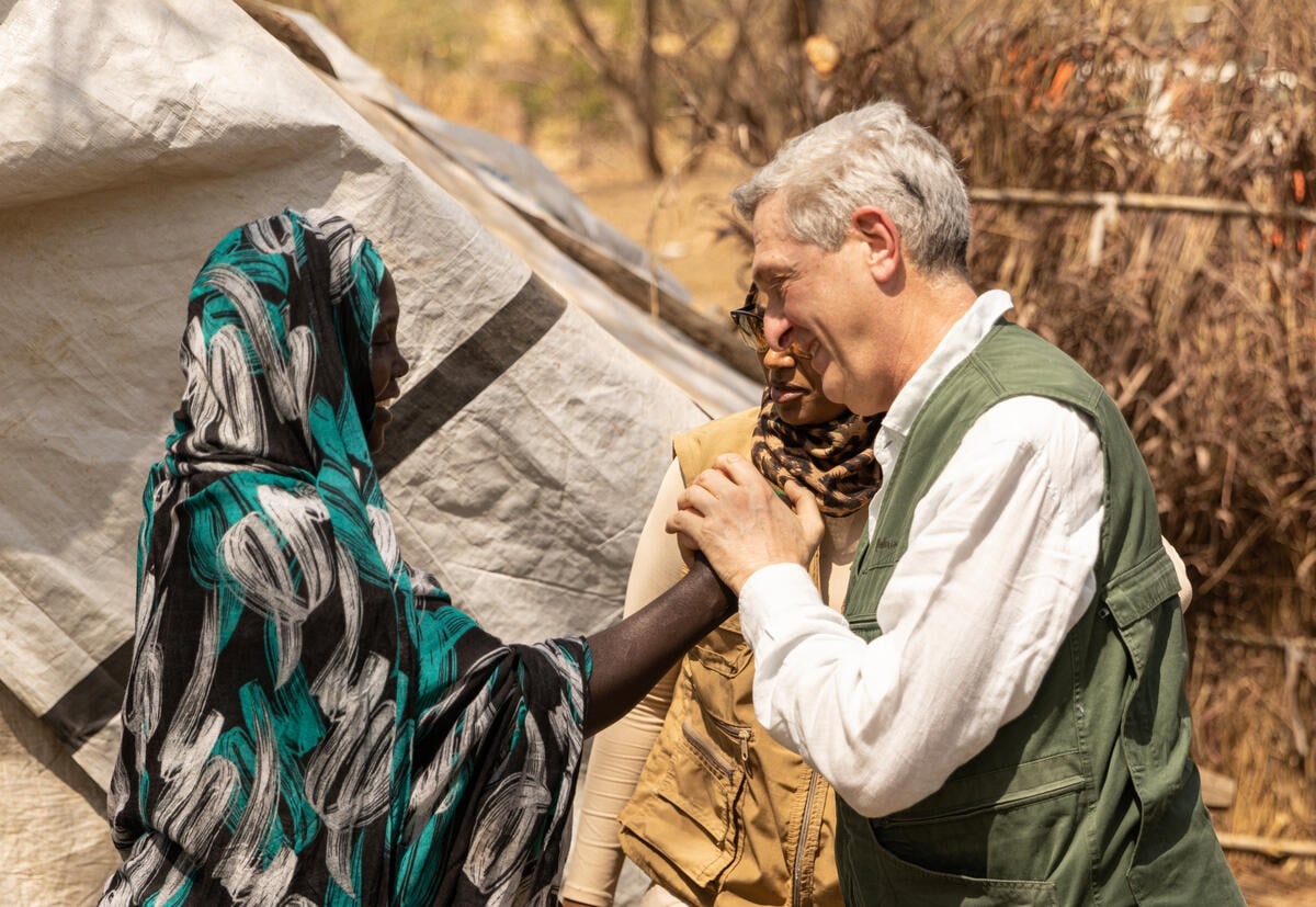 Un homme serre les mains d'une femme tout en se souriant.