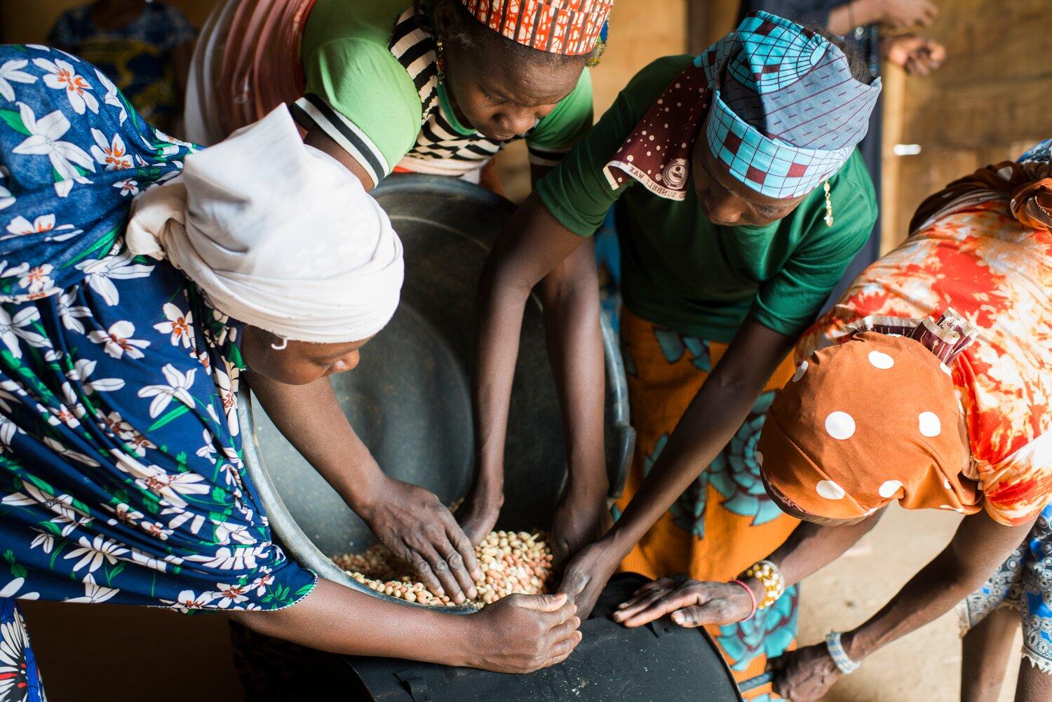 Jamilla Oumaru et trois autres femmes mettent des cacahuètes dans un bol et les mettent au four